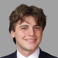 Person wearing black suit smiling